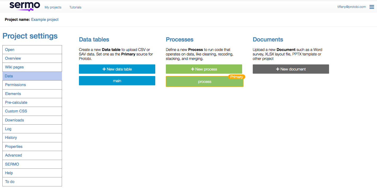 Protobi Project settings page for "Example project" with Data section selected in the left sidebar, displaying three columns: Data tables (with "+ New data table" button and "main" table in blue), Processes (with "+ New process" button and "process" labeled as Primary in green), and Documents (with "+ New document" button in gray).